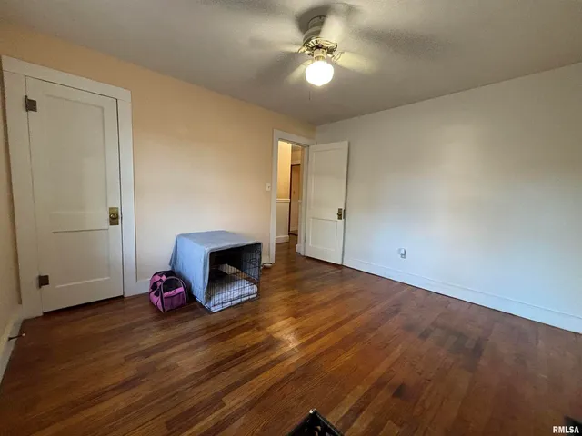 a view of a room with wooden floor and ceiling fan