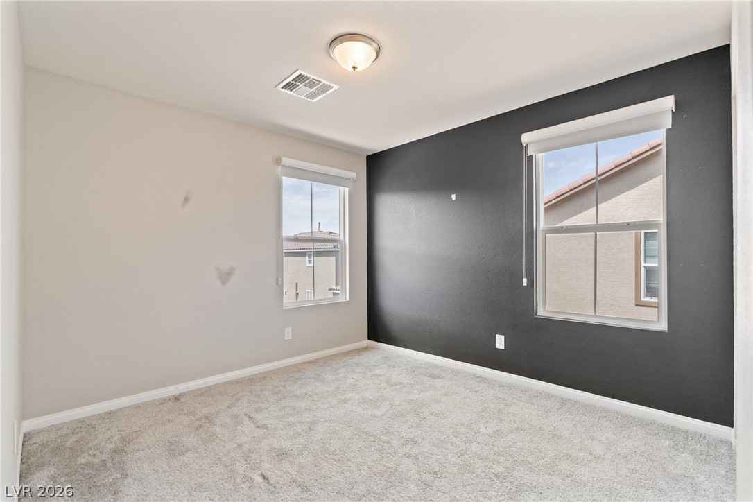 2495 Rofrano Place Henderson, NV 89044 - Photo 11 of 20 Double windows frame neighborhood views in this carpeted bedroom.