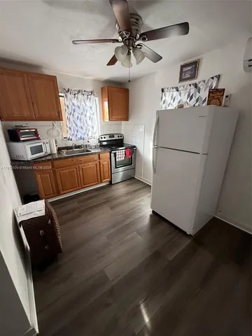 a kitchen with a refrigerator and a stove top oven