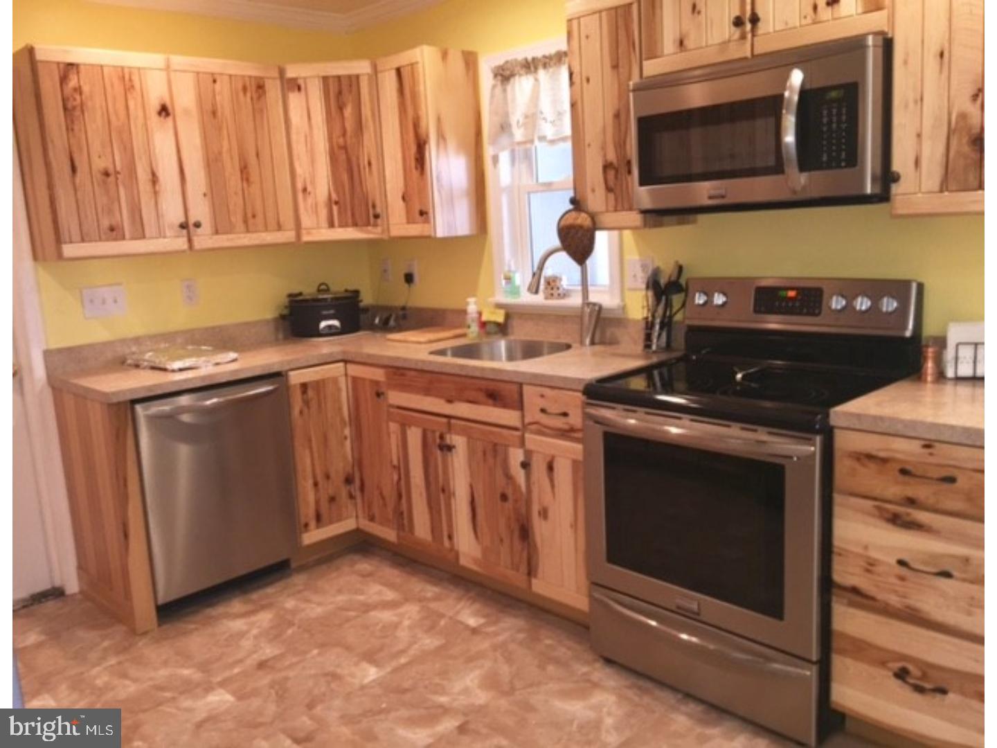 18 Tempo Road Levittown, PA 19056 - Photo 6 of 22 a kitchen with stainless steel appliances a stove a microwave a sink and cabinets