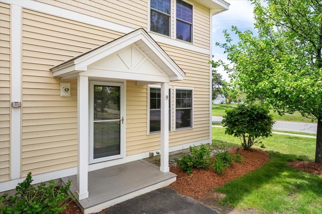 6 Bates Street, Unit A Devens, MA 01434 - Photo 36 of 41 a view of a white house with a yard and a large tree