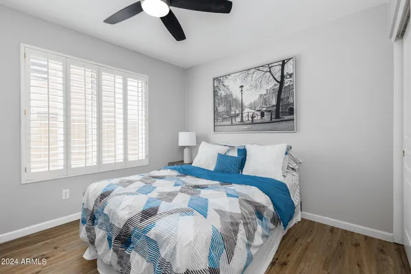 a bedroom with a bed and a painting on the wall