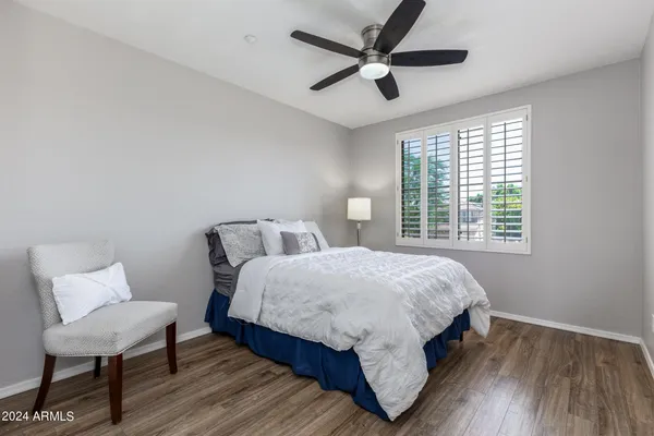 a bedroom with a bed a chair and a large window
