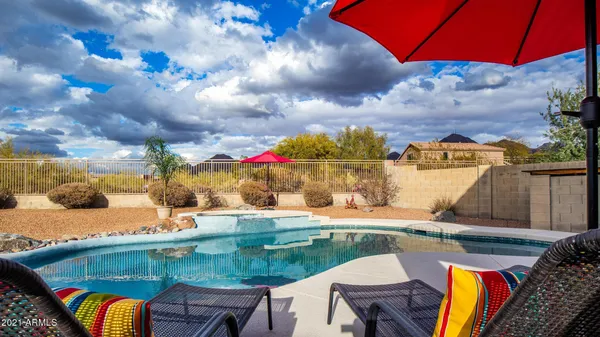 a view of swimming pool with a table and chairs under an umbrella