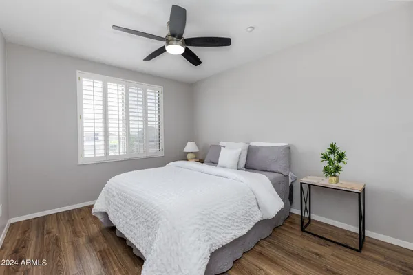 a bedroom with a bed and wooden floor