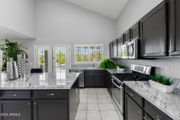 a kitchen with stainless steel appliances granite countertop a stove a sink and a microwave