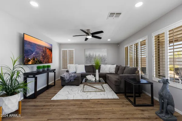 a living room with furniture a flat screen tv and a large window