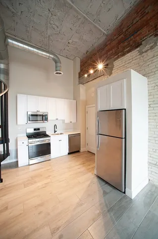 a kitchen with stainless steel appliances a refrigerator and a stove top oven