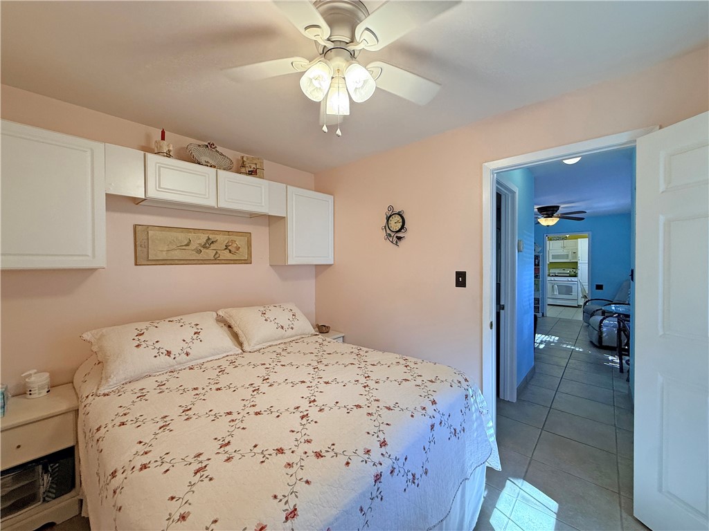 1411 Myrtle Street Fulton, TX 78358 - Photo 15 of 26 a bedroom with a bed and a chandelier