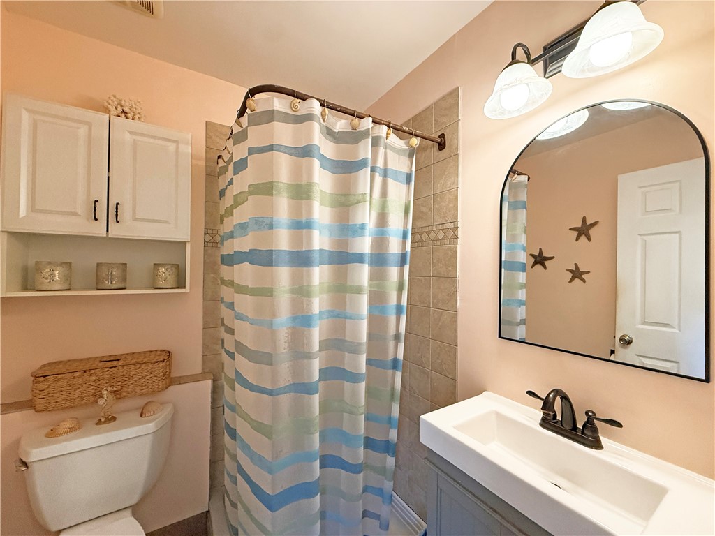 1411 Myrtle Street Fulton, TX 78358 - Photo 17 of 26 a bathroom with a sink toilet and shower