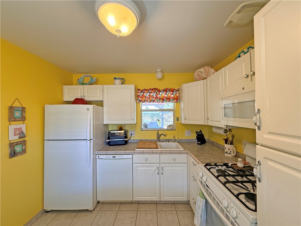 1411 Myrtle Street Fulton, TX 78358 - Photo 9 of 26 a kitchen with a refrigerator and a stove top oven