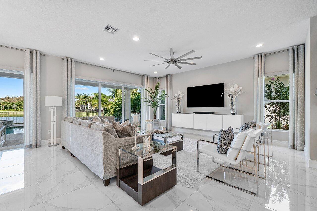 11655 Windy Frst Way Boca Raton, FL 33498 - Photo 13 of 50 a living room with furniture a flat screen tv and a large window