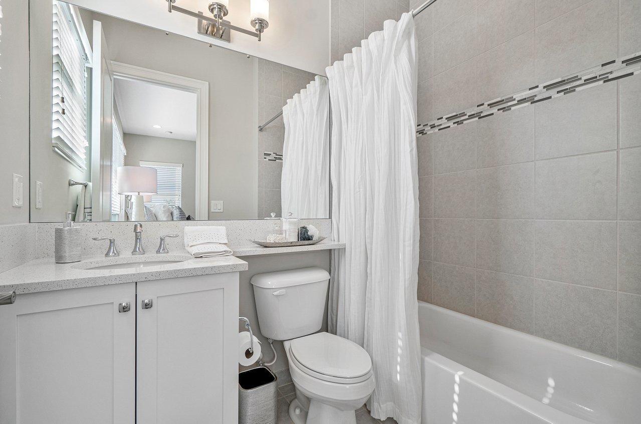 11655 Windy Frst Way Boca Raton, FL 33498 - Photo 22 of 50 a bathroom with a granite countertop toilet sink and a mirror
