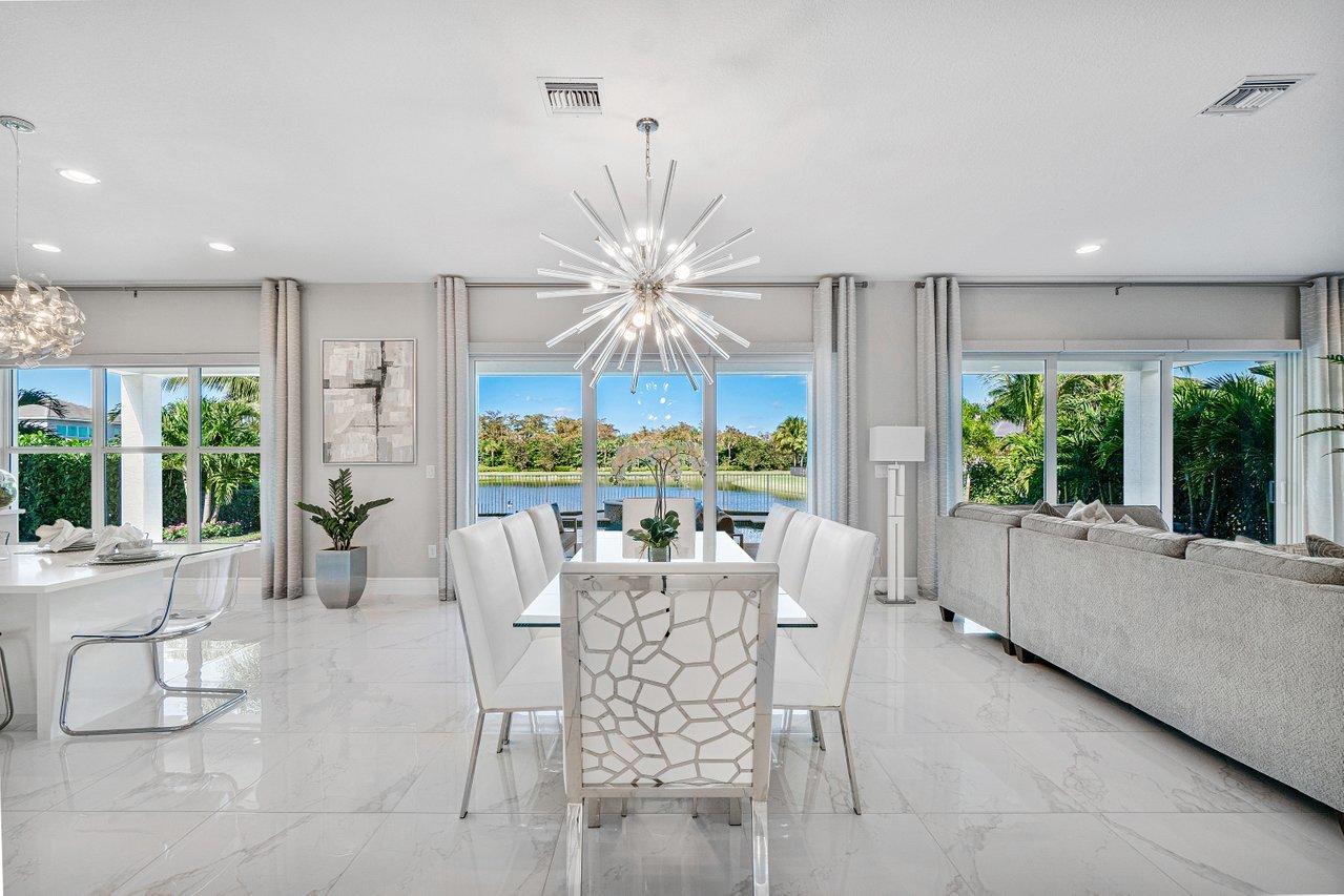 11655 Windy Frst Way Boca Raton, FL 33498 - Photo 10 of 50 a dining room with furniture a chandelier and a large window