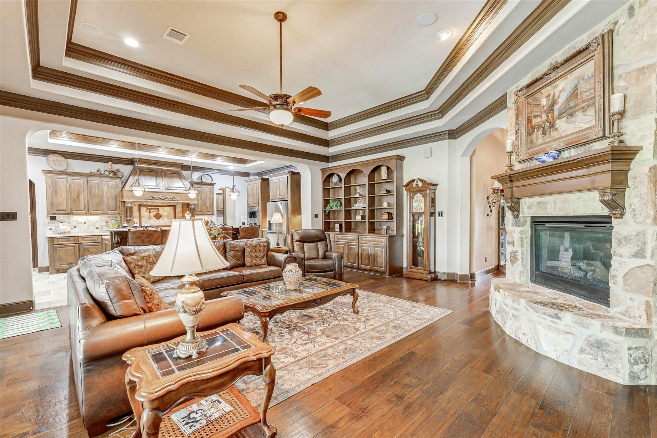 4315 Wickby Street Fulshear, TX 77441 - Photo 12 of 46 a living room with furniture a fireplace and a chandelier