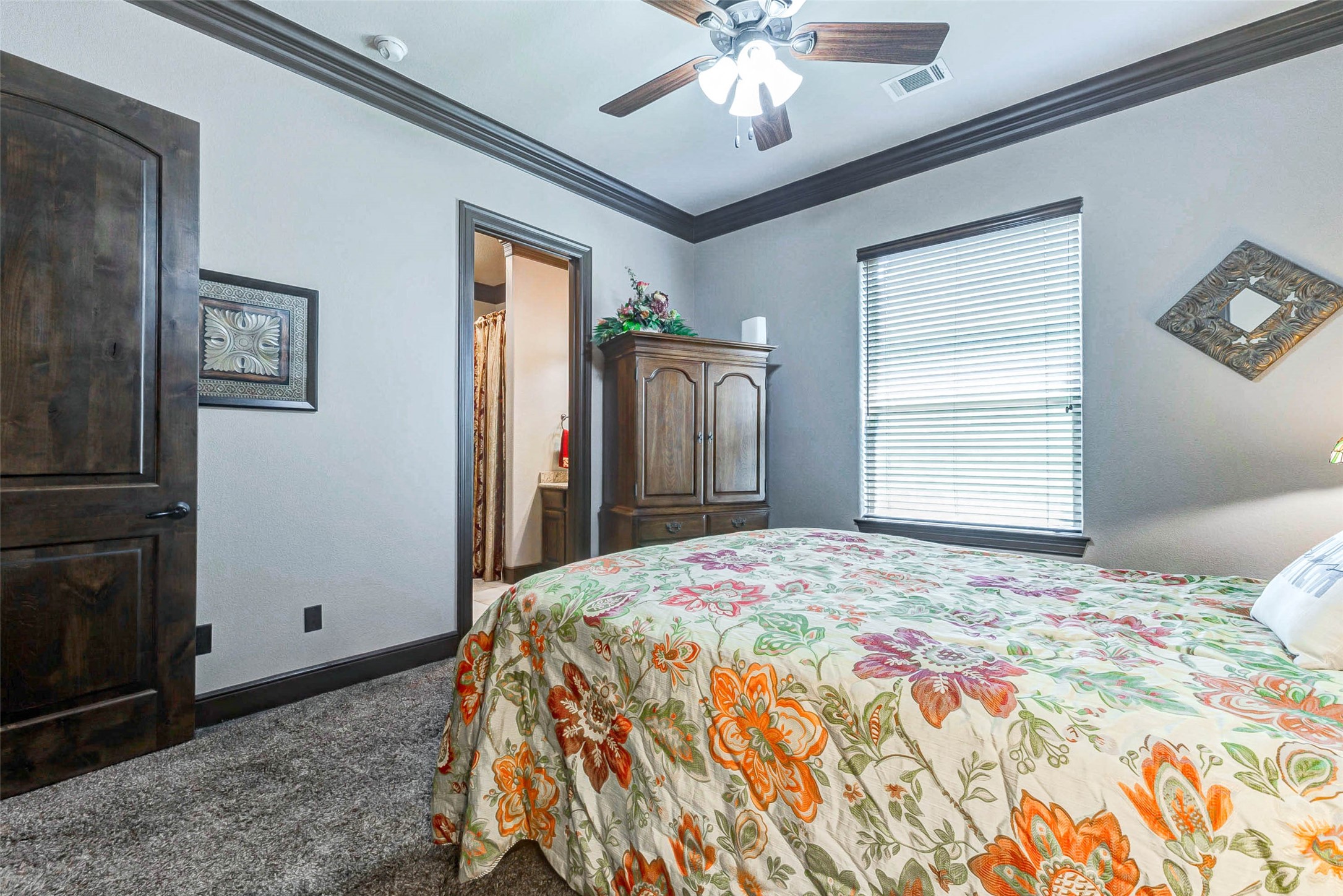 4315 Wickby Street Fulshear, TX 77441 - Photo 22 of 46 a bedroom with a large bed and a chandelier