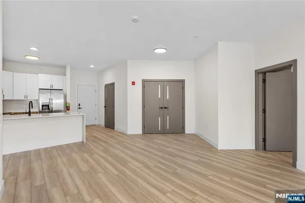 a large kitchen with kitchen island white cabinets and stainless steel appliances