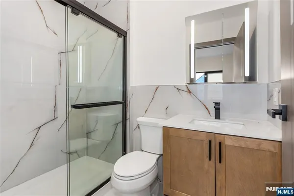 a bathroom with a granite countertop sink toilet and shower