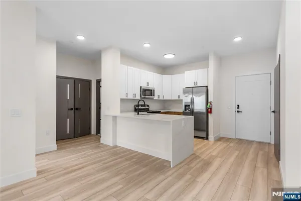 a kitchen with white cabinets and stainless steel appliances