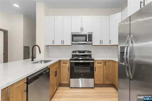 a kitchen with stainless steel appliances granite countertop a stove a refrigerator and a sink