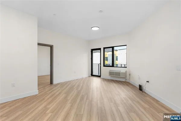 a view of a big room with wooden floor and windows