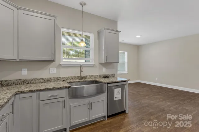 a kitchen with stainless steel appliances granite countertop a sink stove and cabinets