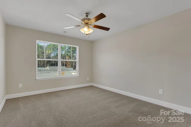 an empty room with closet and a chandelier fan