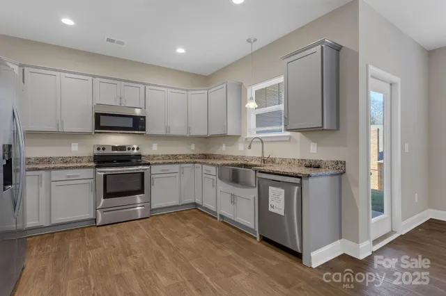 a kitchen with granite countertop a stove top oven sink and cabinets