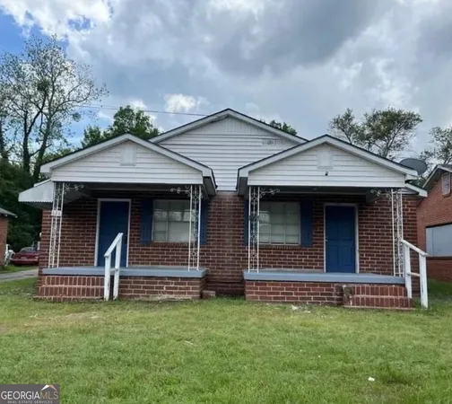 a front view of a house with a garden