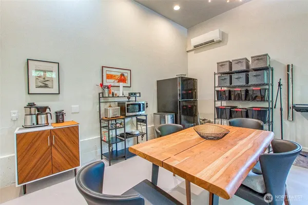 a dining room with stainless steel appliances a table and chairs