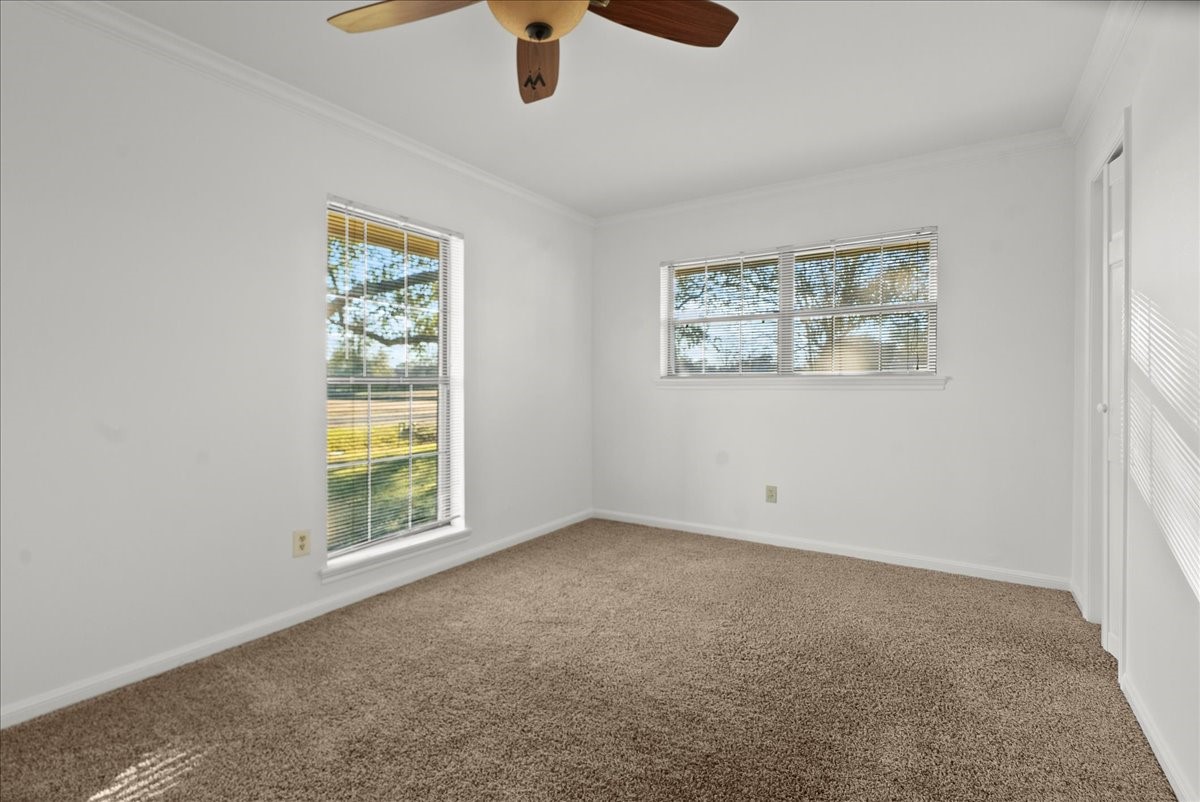 105 Alice Street Anahuac, TX 77514 - Photo 19 of 39 an empty room with windows and fan view