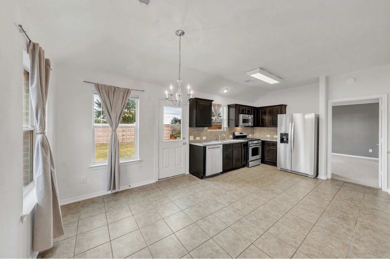 9807 Onyx Trail Drive Rosharon, TX 77583 - Photo 7 of 24 a large white kitchen with a refrigerator a sink dishwasher and a fireplace