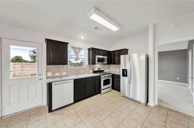 a large kitchen with cabinets and stainless steel appliances