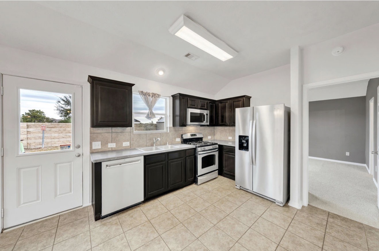 9807 Onyx Trail Drive Rosharon, TX 77583 - Photo 8 of 24 a large kitchen with cabinets and stainless steel appliances