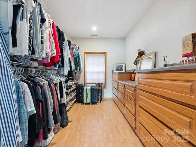 a view of walk in closet with clothes and shoes
