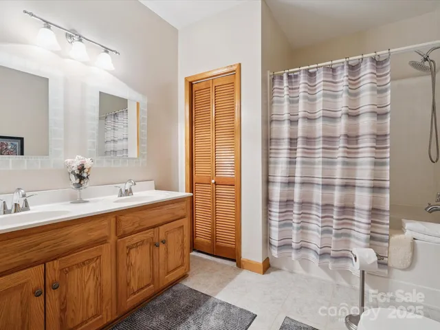 a bathroom with a double vanity sink a toilet and shower