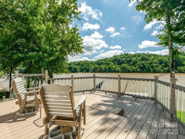 a view of deck with furniture and trees