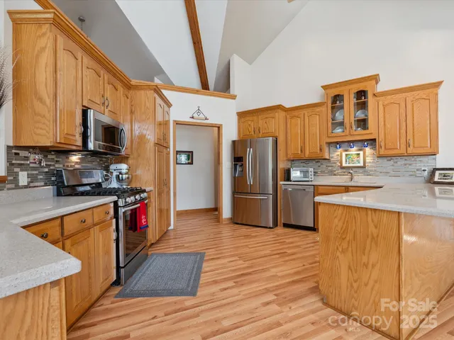 a kitchen with stainless steel appliances granite countertop a refrigerator a stove top oven a sink and dishwasher