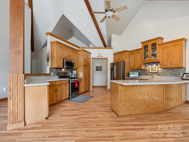 a kitchen with stainless steel appliances kitchen island granite countertop a stove a sink and a refrigerator