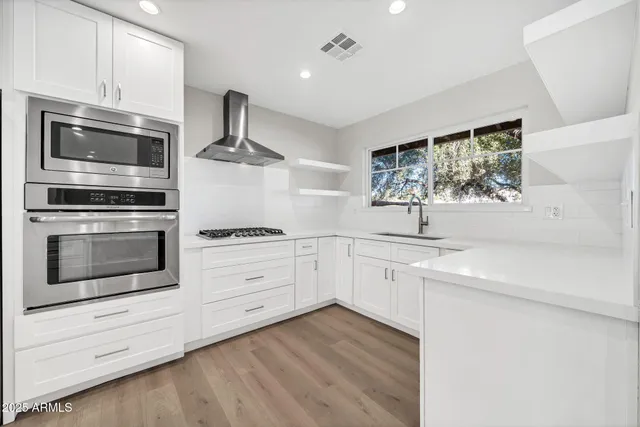 a kitchen with white cabinets and appliances