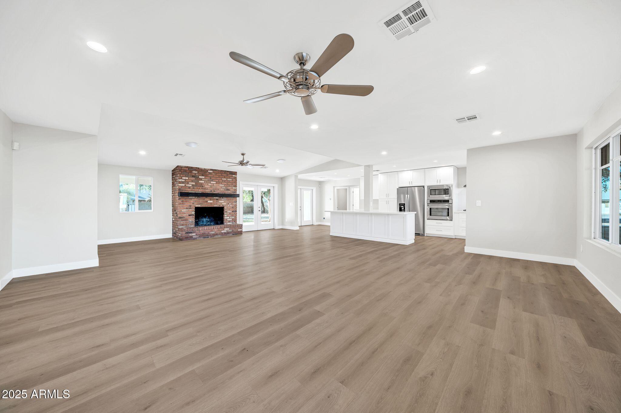 641 West Linger Lane Phoenix, AZ 85021 - Photo 2 of 38 a view of empty room with wooden floor fireplace and windows