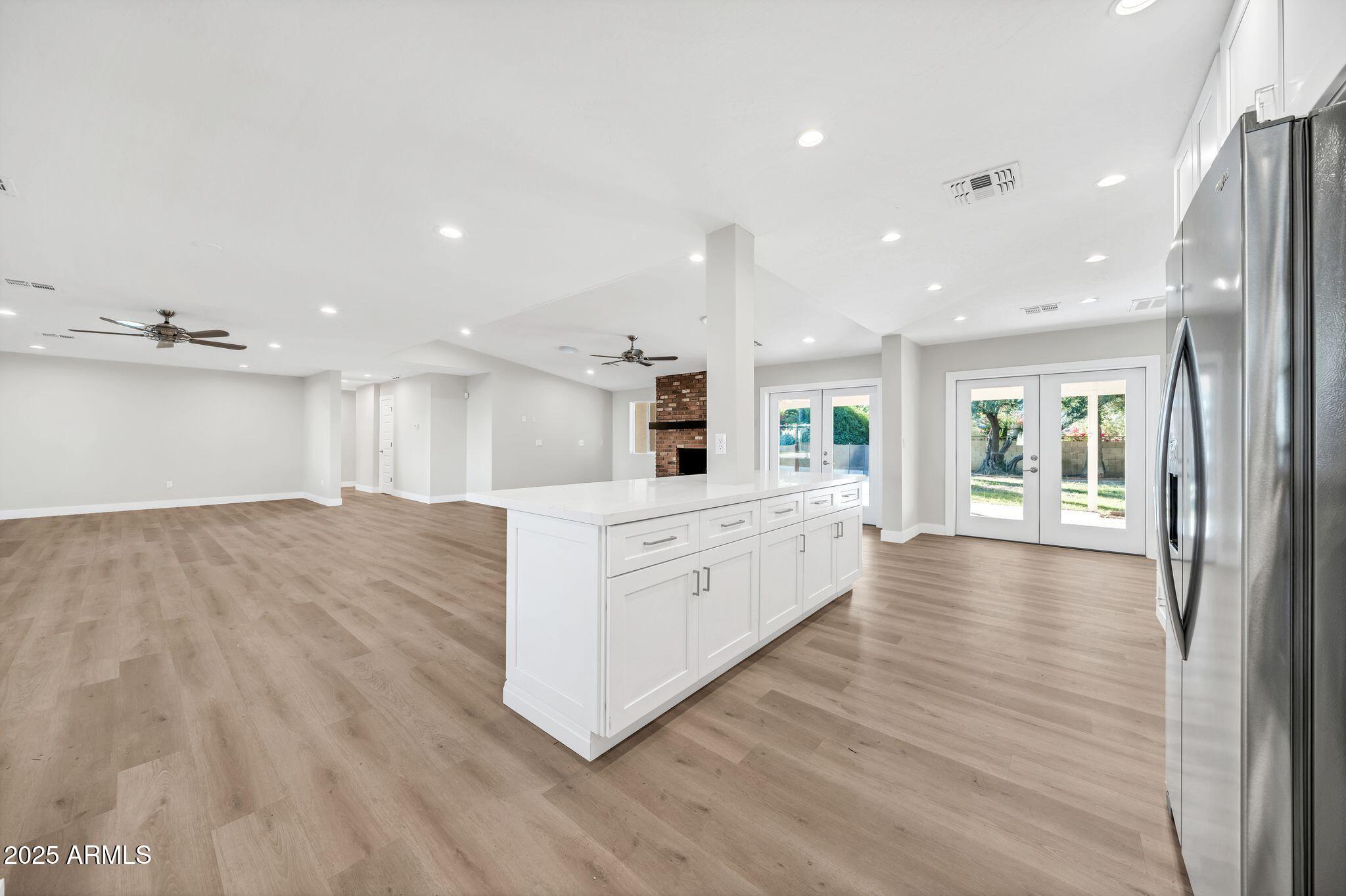 641 West Linger Lane Phoenix, AZ 85021 - Photo 3 of 38 a kitchen with stainless steel appliances kitchen island wooden floors granite counter tops and a view of living room