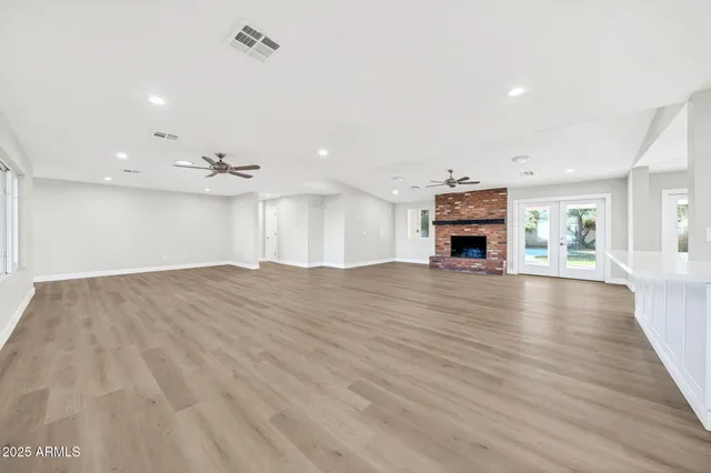 a kitchen with stainless steel appliances kitchen island wooden floors granite counter tops and a view of living room