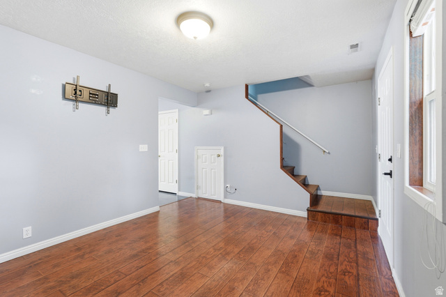 338 South 370 West Logan, UT 84321 - Photo 13 of 33 Spacious interior featuring wood-finish flooring, a built-in staircase, and light gray wall tones
