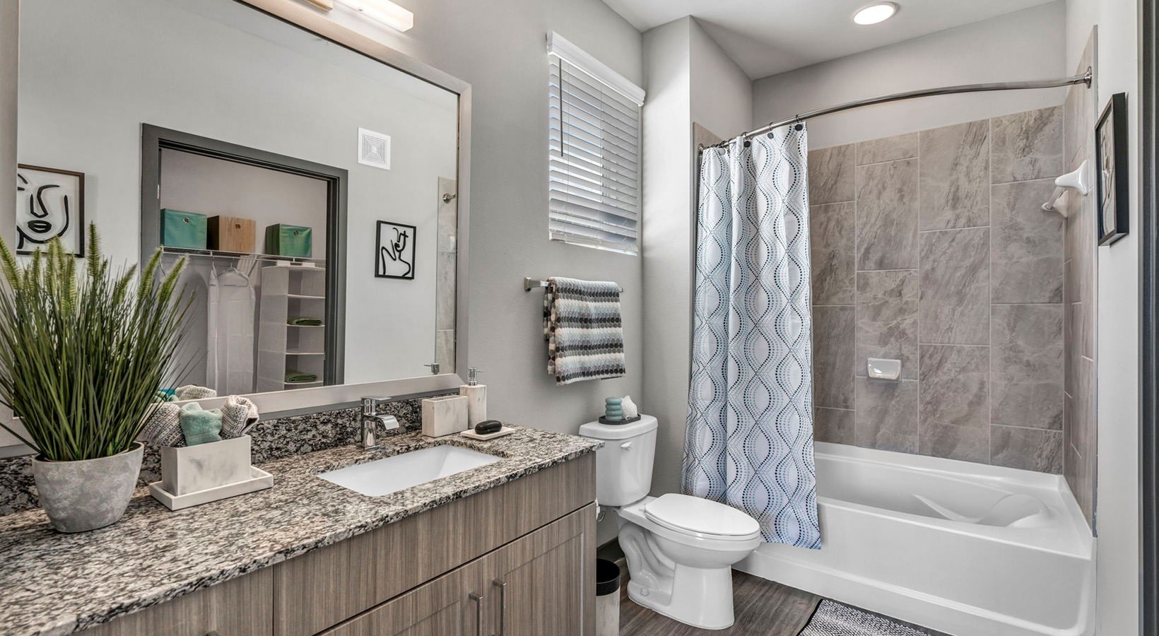 8811 Fm Road, Unit 1207 Richmond, TX 77407 - Photo 9 of 11 a bathroom with a granite countertop sink toilet a large mirror a shower and a bathtub