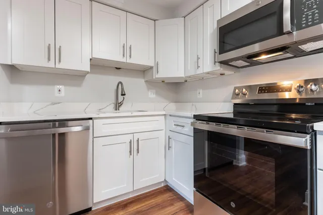 a kitchen with stainless steel appliances granite countertop a stove microwave and cabinets