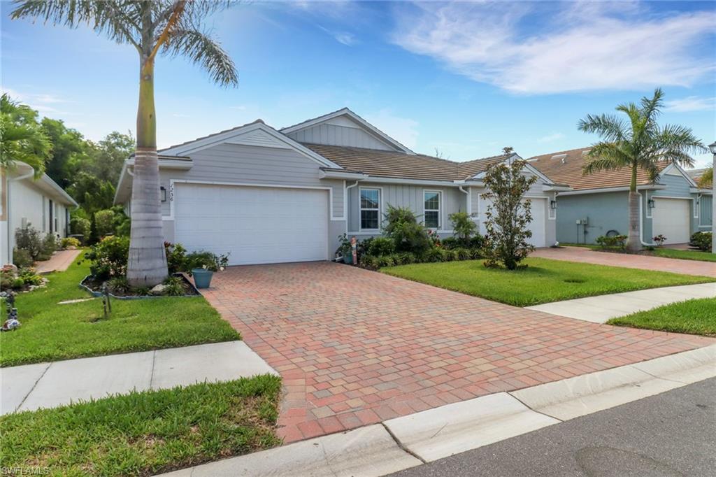 1256 Enbrook Loop Naples, FL 34114 - Photo 1 of 35 a front view of a house with a garden and palm trees