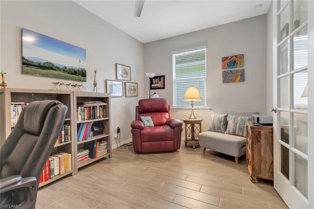 1256 Enbrook Loop Naples, FL 34114 - Photo 13 of 35 a living room with furniture and a book shelf