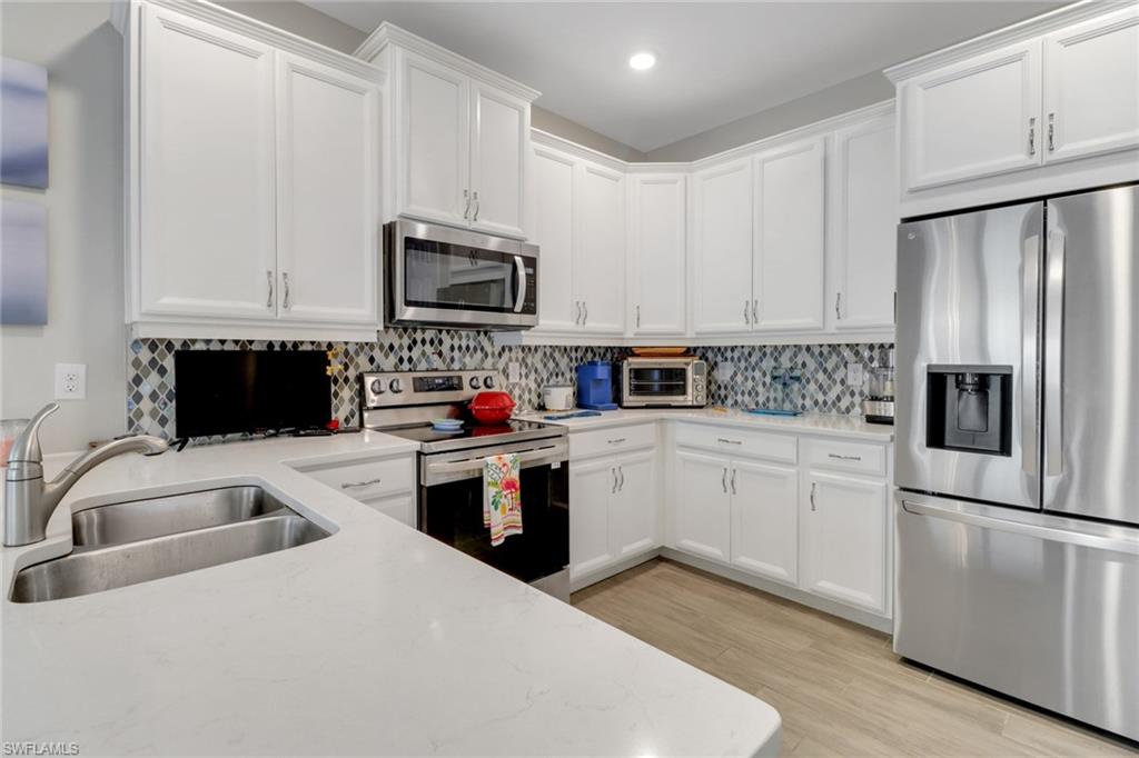 1256 Enbrook Loop Naples, FL 34114 - Photo 5 of 35 a kitchen with cabinets stainless steel appliances and a sink