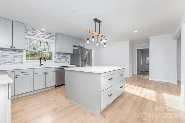 a kitchen with stainless steel appliances a white cabinets and stove top oven